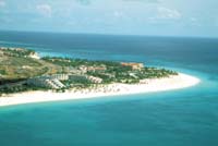 Un brazo de arena, palmeras y Divi Divi tendido sobre el Caribe.