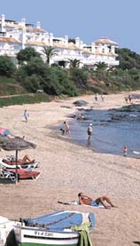 Tejas rojas y casas blancas sobre una de las playas de la costa de Andaluc&iacute;a.