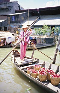 Gondoleros de extremo oriente. Barcazas cargadas de frutos en el delta del Mekong.