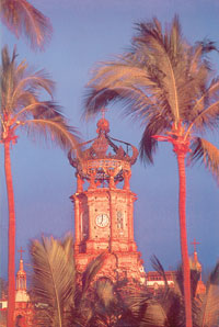 El atardecer tiñe de rojo la corona que remata la torre de la iglesia de Guadalupe.