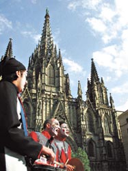 Frente a la Catedral, sobre la Pla de la Seu, tres uruguayos de caras pintadas entonan canciones murgueras.