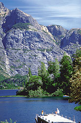Moles de roca, bosques y un muelle adentr&aacute;ndose en las aguas azules.