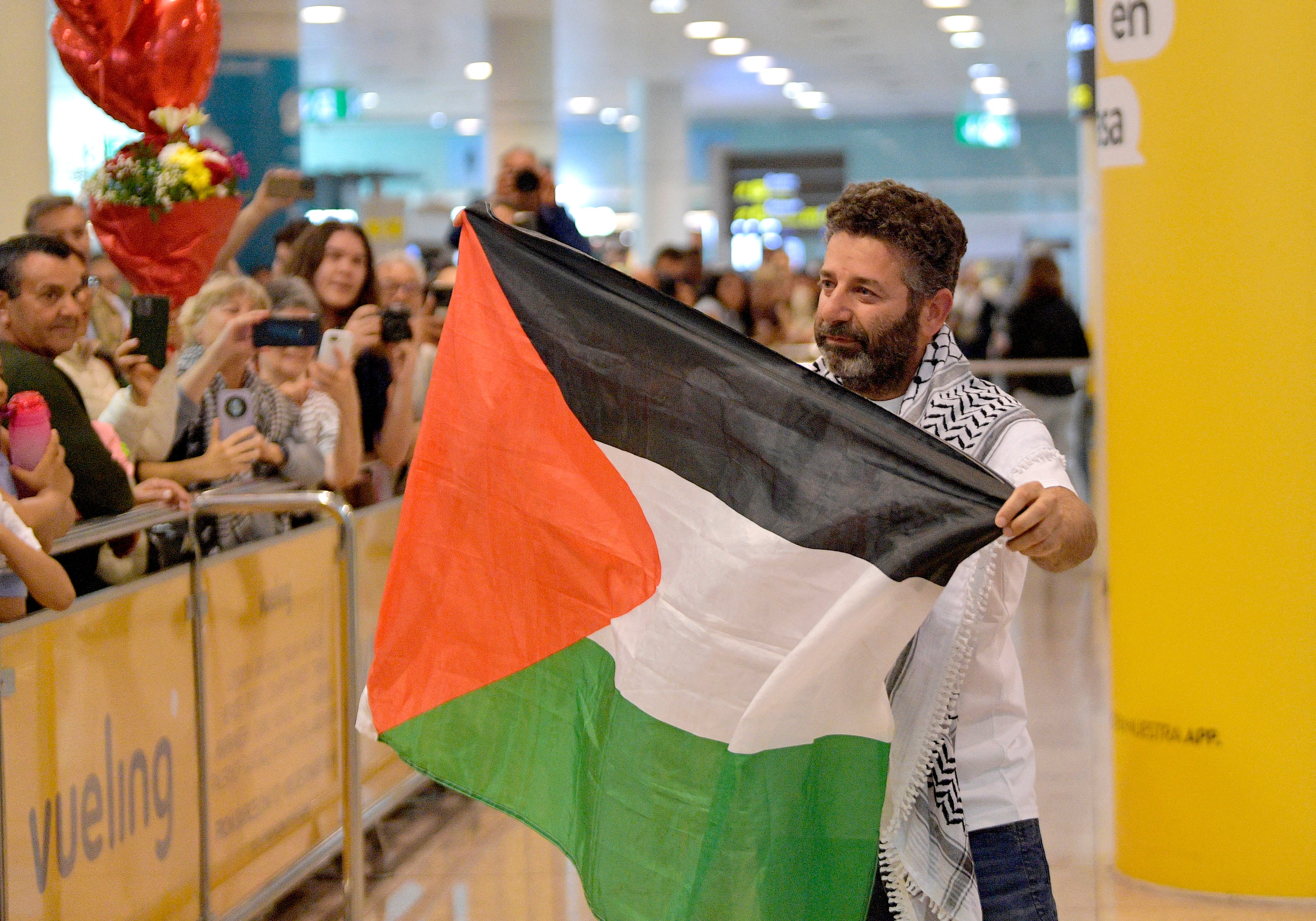 Spanish activist from a Gaza-bound aid flotilla Saif Abu Keshek waves a Palestinian flag he arrives after being released by Israeli authorities at Barcelona airport, on May 10, 2026. Israeli forces intercepted the flotilla in international waters off Greece last week, expelling the activists to Europe but arresting Abu Keshek and another activist from Gaza-bound aid flotilla. (Photo by MANAURE QUINTERO / AFP)