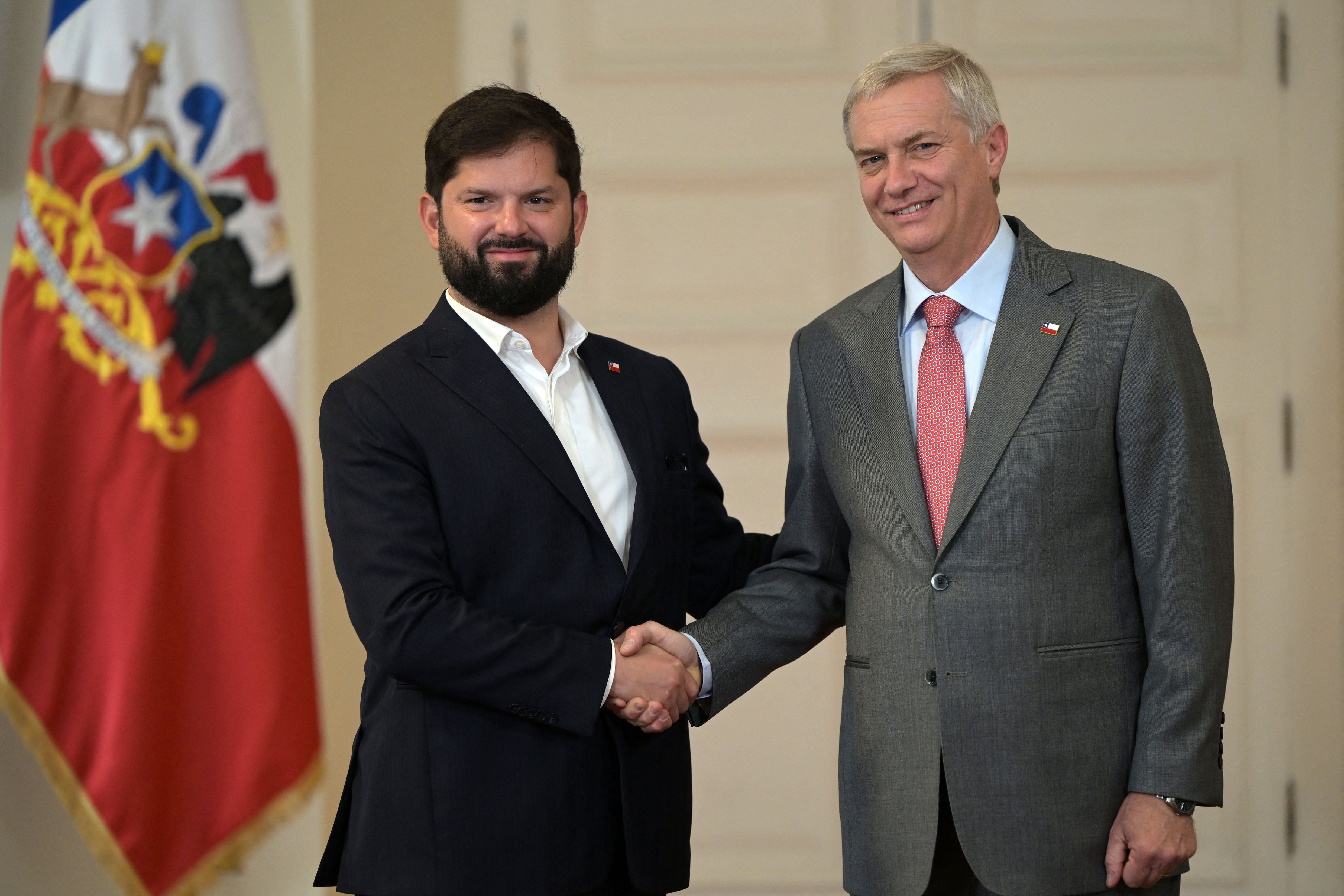 Chile's President Gabriel Boric (L) shakes hands with Chile's president-elect Jose Antonio Kast at La Moneda presidential palace in Santiago, on December 15, 2025, the day after the presidential runoff election. Chile elected its most right-wing president in 35 years of democracy on Sunday, with arch-conservative Jose Antonio Kast scoring a thumping victory over his leftist runoff rival. (Photo by Rodrigo ARANGUA / AFP)