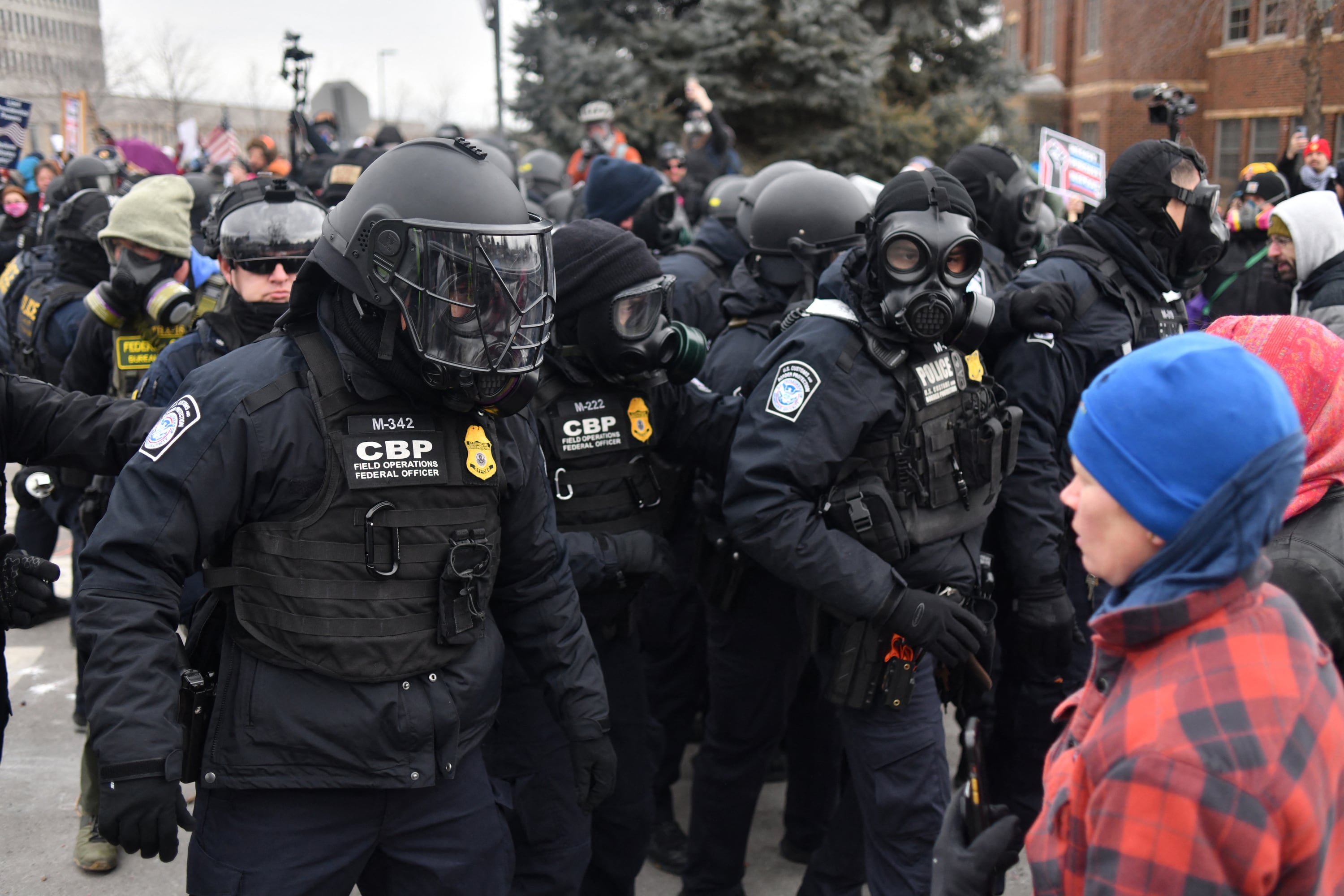 Federal law enforcement agents confront anti-ICE protesters during a demonstration outside the Bishop Whipple Federal Building in Minneapolis, Minnesota, on January 15, 2026. Hundreds more federal agents were heading to Minneapolis, the US homeland security chief said on January 11, brushing aside demands by the Midwestern city's Democratic leaders to leave after an immigration officer fatally shot a woman protester. In multiple TV interviews, US Homeland Secretary Kristi Noem defended the actions of the officer who shot and killed 37-year-old Renee Nicole Good, whose death has sparked renewed protests nationwide against President Donald Trump's immigration crackdown. (Photo by Octavio JONES / AFP)