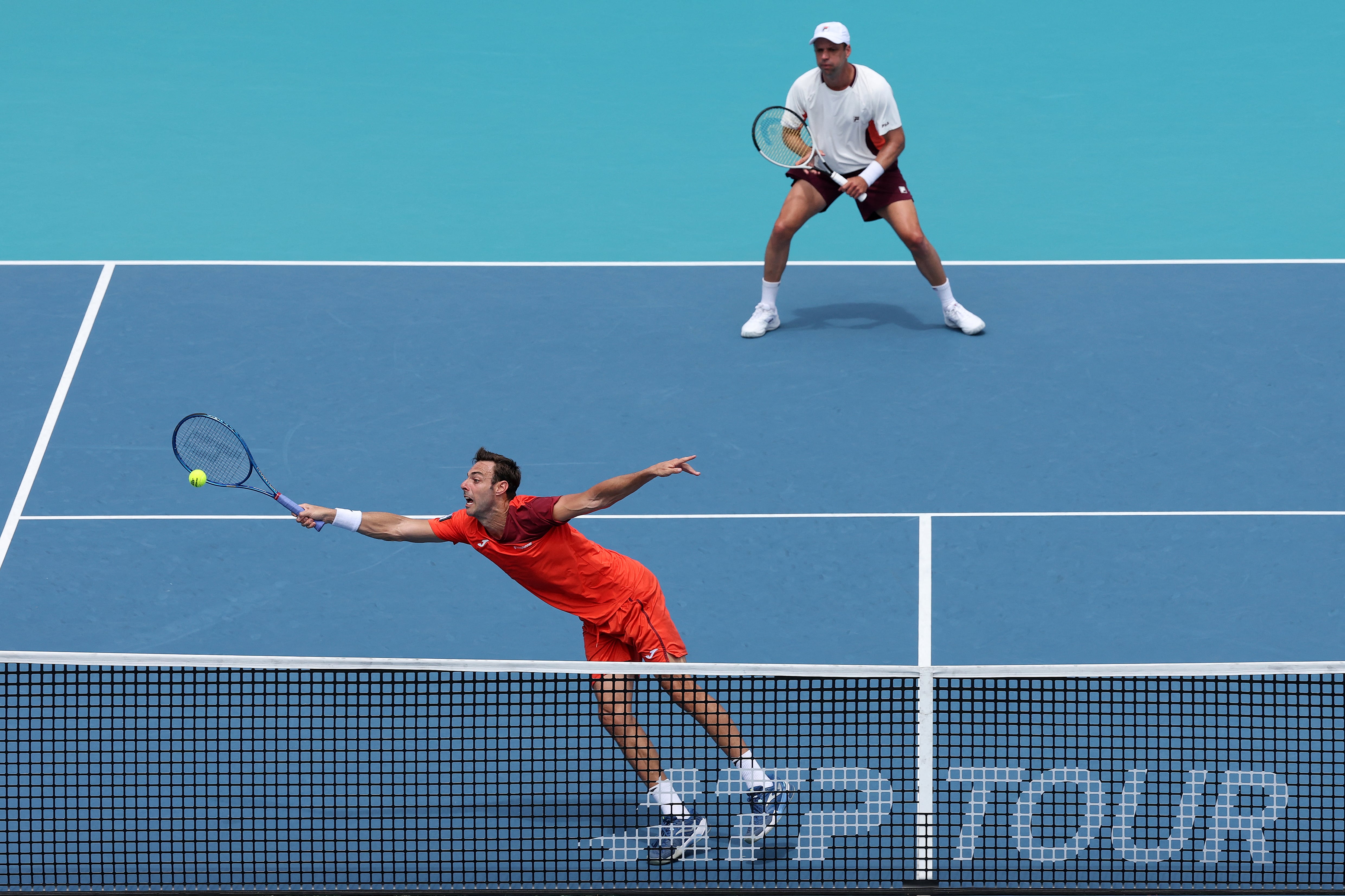MIAMI GARDENS, FLORIDA - MARCH 27: Marcel Granollers of Spain lunges for a ball against Henry Patten of Great Britain and Harri Heliovaara of Finland while playing with Horacio Zeballos of Argentina during the Men's Double's Semifinals on Day 11 of the Miami Open Presented by Itau at Hard Rock Stadium on March 27, 2026 in Miami Gardens, Florida. Matthew Stockman/Getty Images/AFP (Photo by MATTHEW STOCKMAN / GETTY IMAGES NORTH AMERICA / Getty Images via AFP)