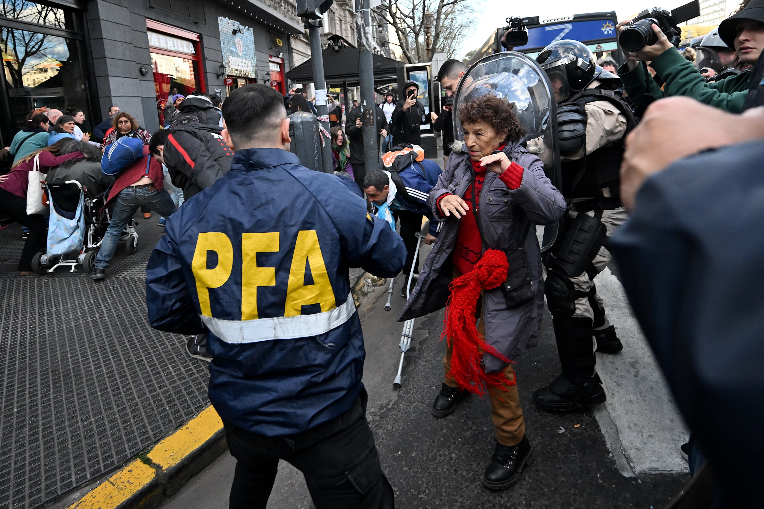 A woman confronts a member of the Argentine Federal Police during a protest against Argentine President Javier Milei's veto of the pension mobility law in front of the National Congress in Buenos Aires on September 4, 2024. Argentina's President Javier Milei vetoed an 8.1% increase in retirement and pensions approved by a large majority in the legislature, according to his decision published on September 2, 2024, in the Official Gazette. (Photo by Luis ROBAYO / AFP)