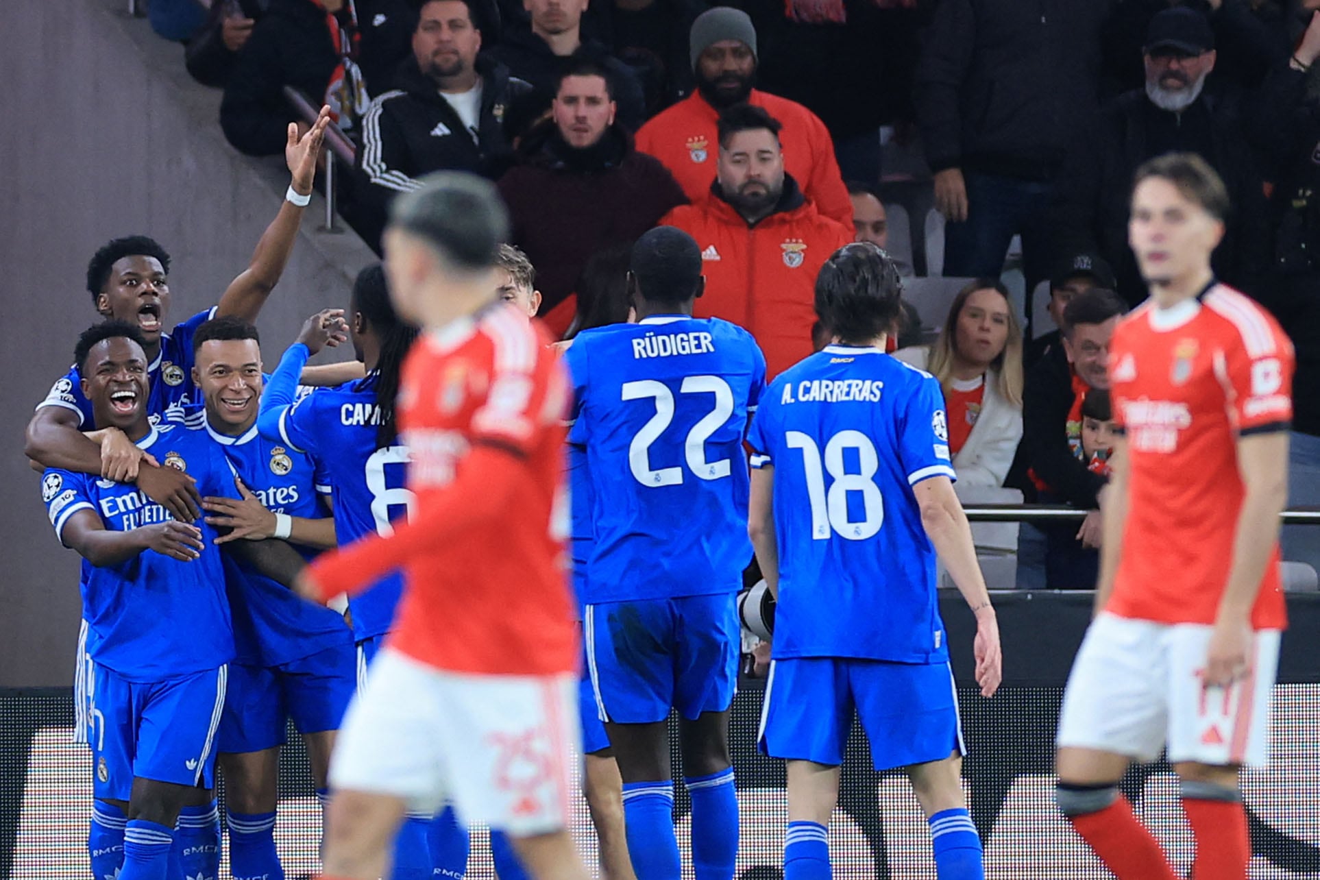 Real Madrid's Brazilian forward #07 Vinicius Junior (L) celebrates scoring his team's first goal during the UEFA Champions League knockout round play-off first leg football match between SL Benfica and Real Madrid CF at Estadio da Luz in Lisbon on February 17, 2026. (Photo by PATRICIA DE MELO MOREIRA / AFP)