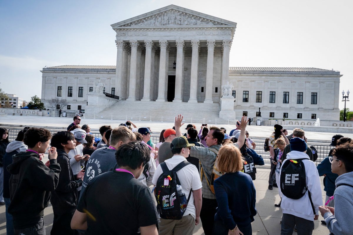 WASHINGTON, DC - MARCH 31: Students listen to a man explaining the significance of the statues adorning the U.S. Supreme Court building on March 31, 2026