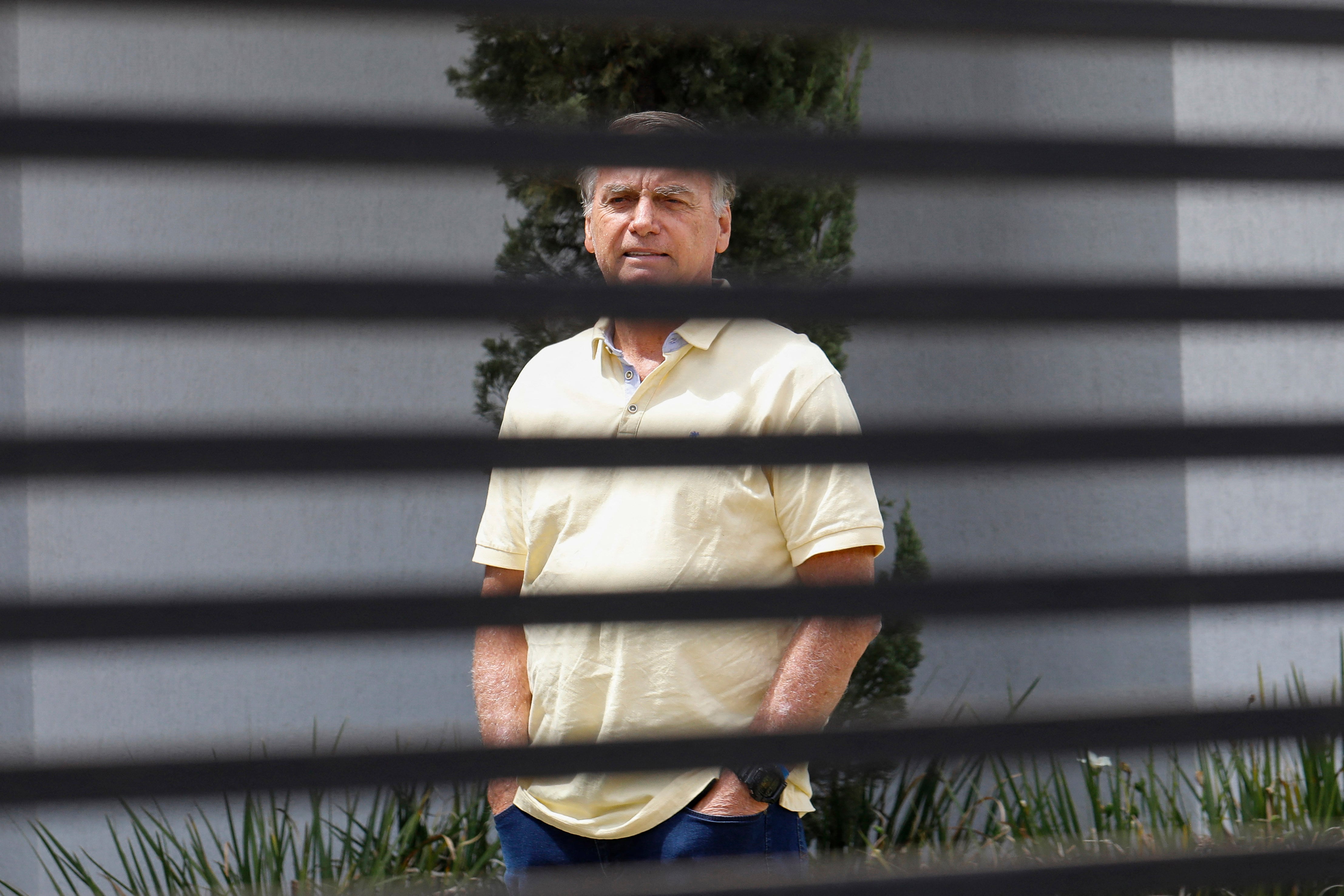Former Brazilian President Jair Bolsonaro gestures from his residence in Brasilia on September 3, 2025. Brazil's Supreme Court on Tuesday began verdict deliberations in the trial of former president Jair Bolsonaro, who is accused of plotting a coup to attempt to retain power after he lost the 2022 election. (Photo by Sergio Lima / AFP)