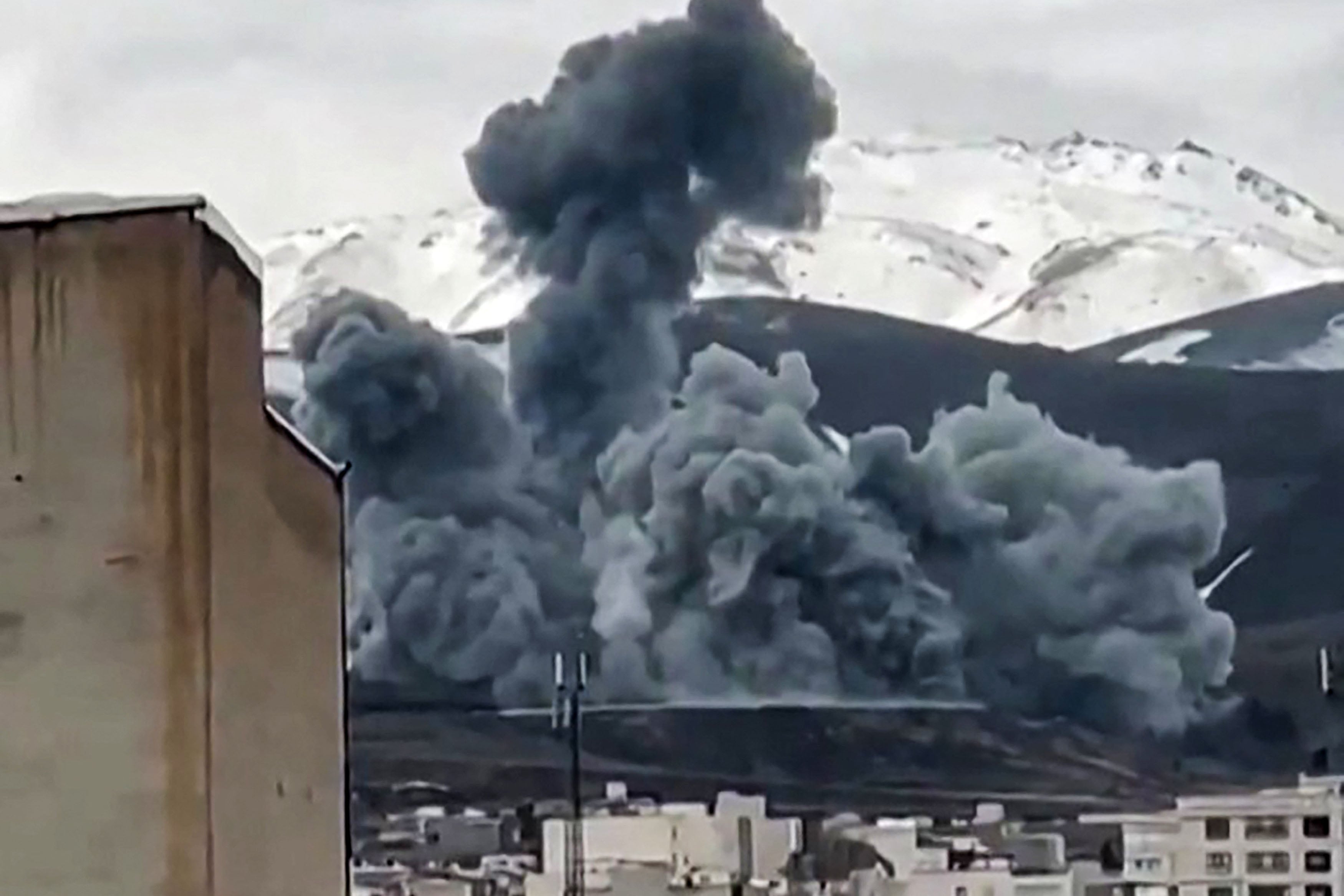 This video grab taken from UGC images posted on social media and verified by AFPTV staff on March 16, 2026, show smoke rising from the side of a mountain in Hamedan, in Hamedan Province, western Iran. On February 28, Israel and the United States launched strikes on Iran, killing its supreme leader and triggering a war that spread across the Middle East and unleashed chaos across global markets and sent oil prices soaring. (Photo by UGC / AFP) /