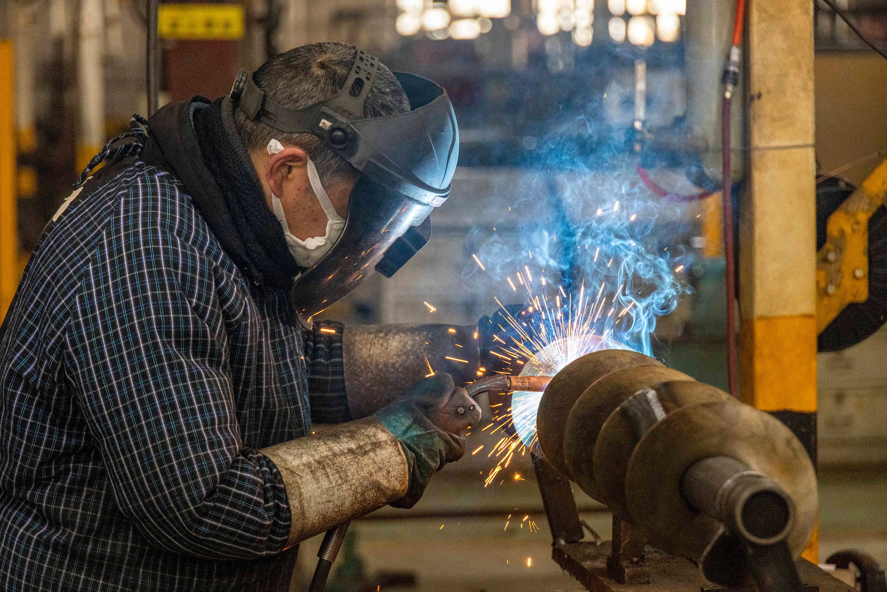 Un empleado suelda piezas de maquinaria de cosechadora en una fábrica que produce equipos agrícolas en Taizhou, en la provincia oriental china de Jiangsu, el 27 de febrero de 2024. (Foto de AFP) / China OUT / CHINA OUT