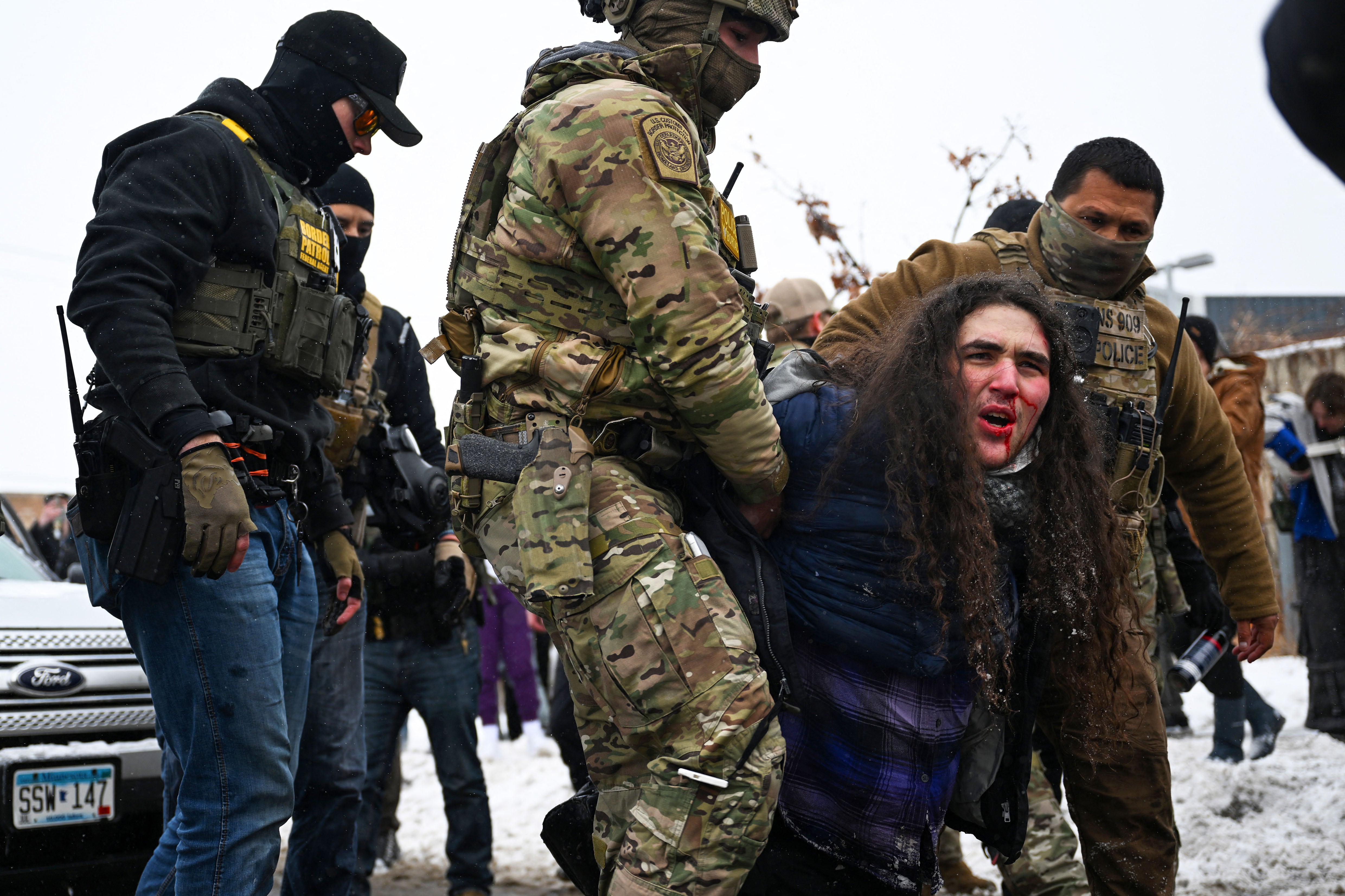 MINNEAPOLIS, MINNESOTA - JANUARY 21: A person is detained by U.S. Border Patrol agents during a confrontation in an intersection on January 21, 2026 in Minneapolis, Minnesota. A reported 3,000 Department of Homeland Security federal agents have been deployed to the state, with more on the way, amid the Trump administration's major crackdown on immigration enforcement. Brandon Bell/Getty Images/AFP (Photo by Brandon Bell / GETTY IMAGES NORTH AMERICA / Getty Images via AFP)