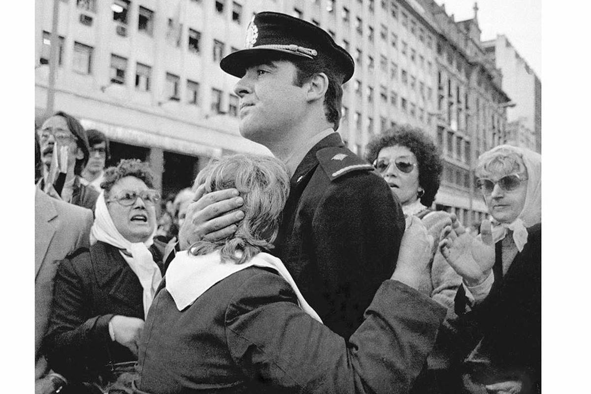 Carlos Enrique Gallone que abraza a una madre de plaza de Mayo