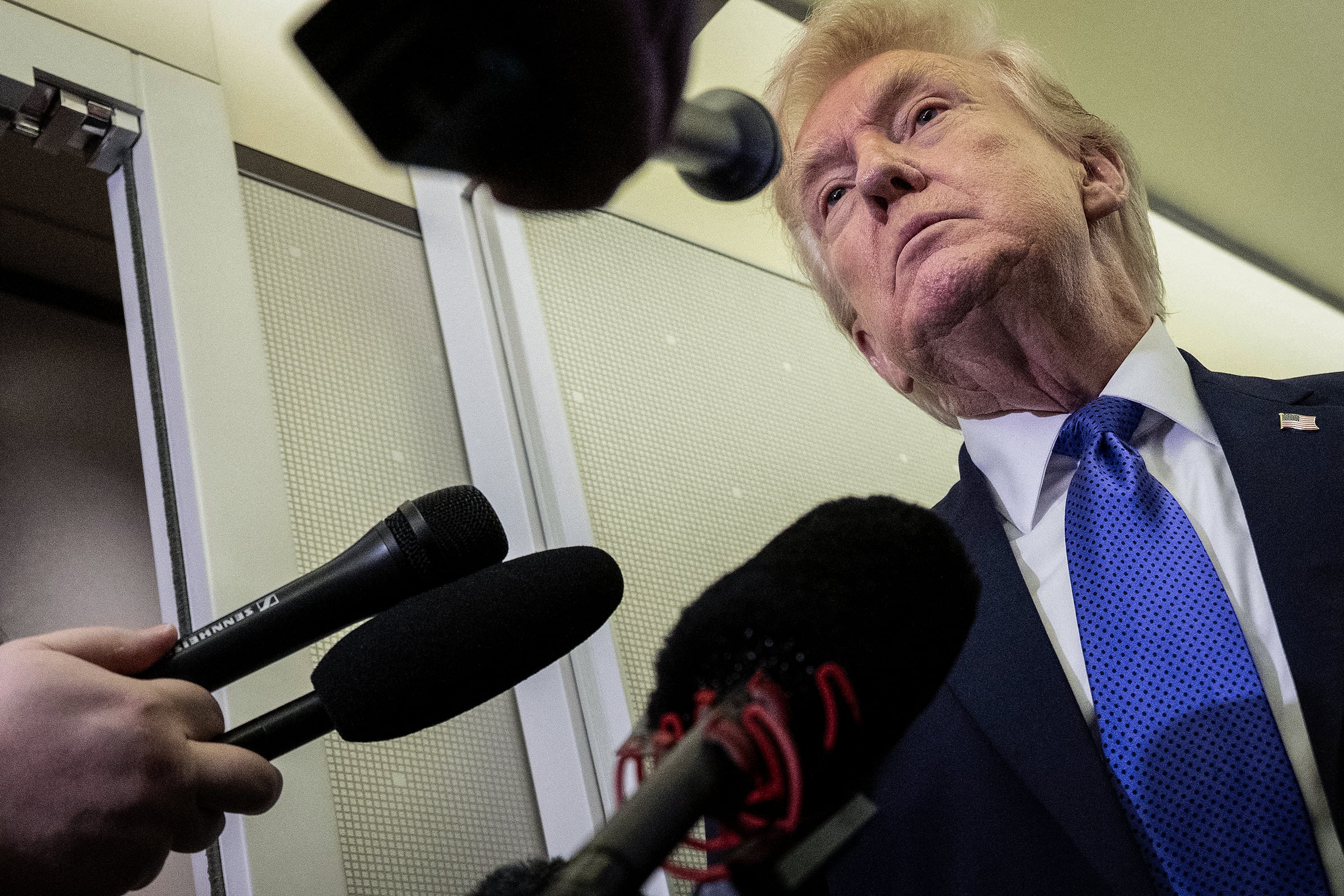 US President Donald Trump speaks with reporters aboard Air Force One on his way to Palm Beach International Airport on February 6, 2026.