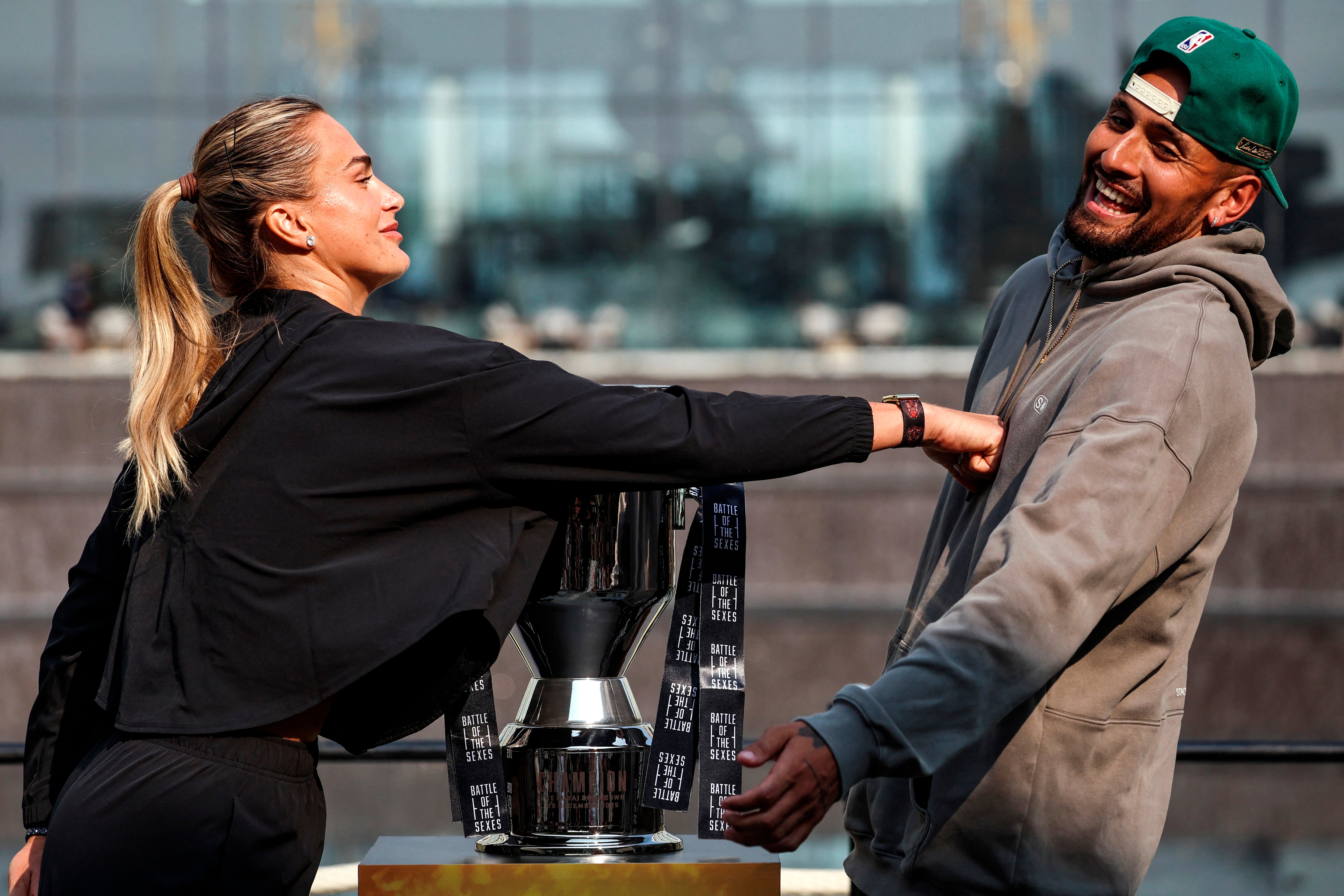 Belarus’ Aryna Sabalenka (L) pushes Australia's Nick Kyrgios during a press conference on the eve of the Battle of the Sexes exhibition match between Sabalenka and Kyrgios at Atlantis The Royal, in Dubai on December 27, 2025. (Photo by FADEL SENNA / AFP)