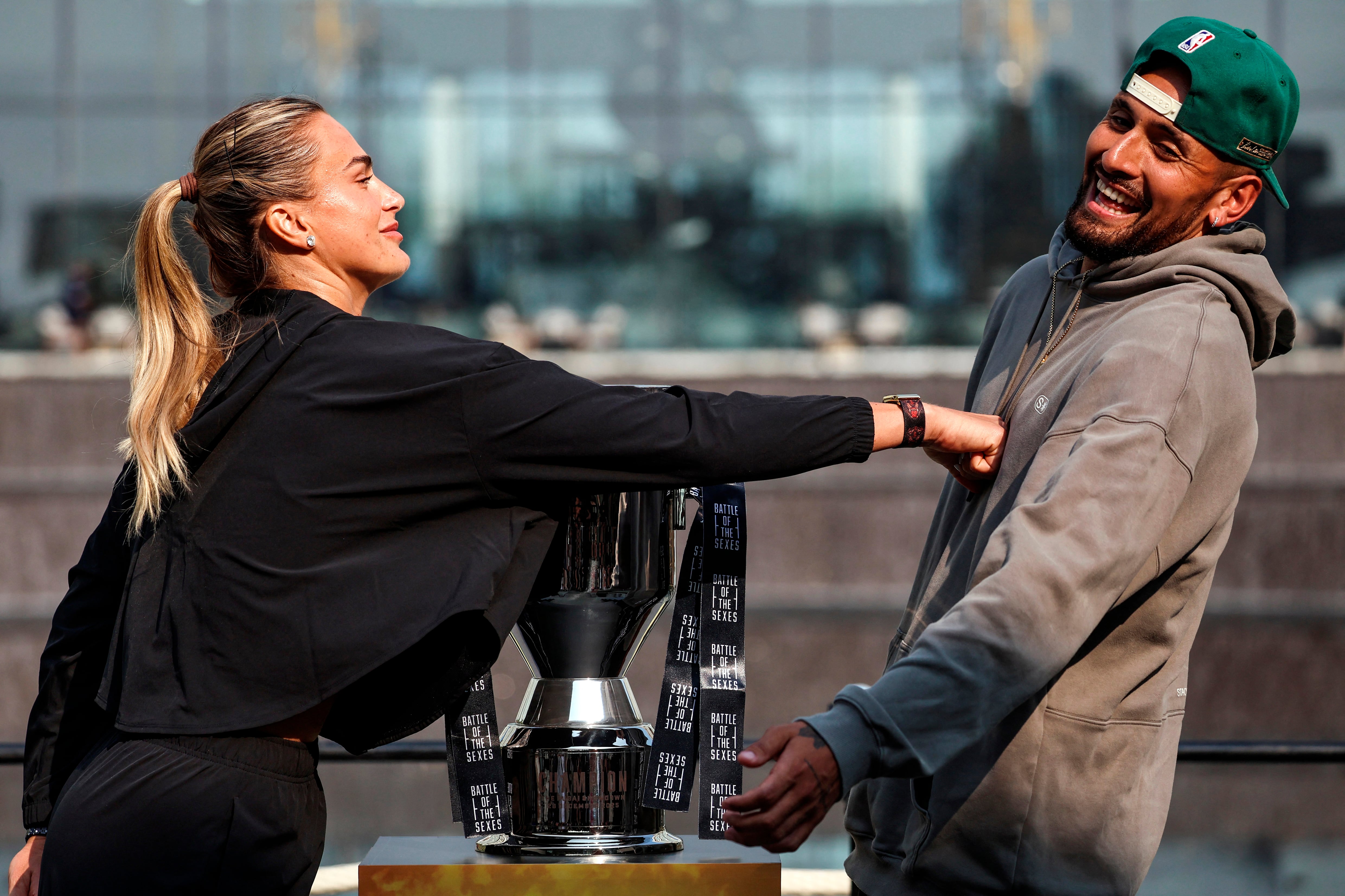 Belarus’ Aryna Sabalenka (L) pushes Australia's Nick Kyrgios during a press conference on the eve of the Battle of the Sexes exhibition match between Sabalenka and Kyrgios at Atlantis The Royal, in Dubai on December 27, 2025. (Photo by FADEL SENNA / AFP)