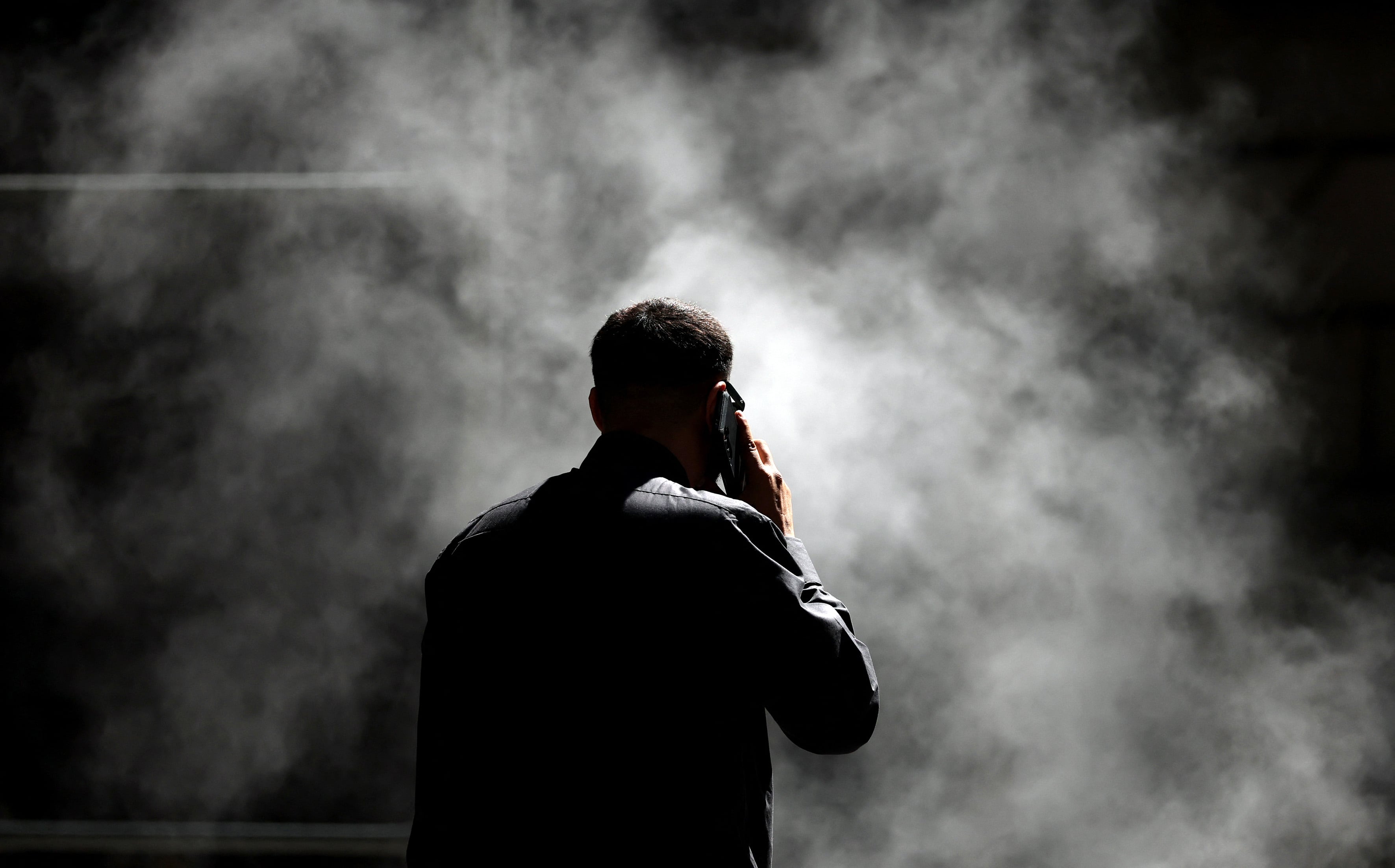 Un hombre habla por teléfono mientras está cerca de una tubería de vapor cerca de la Bolsa de Valores de Nueva York (NYSE) en Nueva York el 17 de abril de 2025. Los mercados de valores vacilaron el jueves a pesar de otro recorte de las tasas de interés por parte del Banco Central Europeo, ya que los inversores siguen en el borde de las consecuencias de la tormenta de aranceles del presidente Donald Trump. En Nueva York, el Dow y el Nasdaq, de alta tecnología, extendieron las pérdidas, mientras que el amplio S&P 500 subió. (Foto de TIMOTHY A. CLARY / AFP)