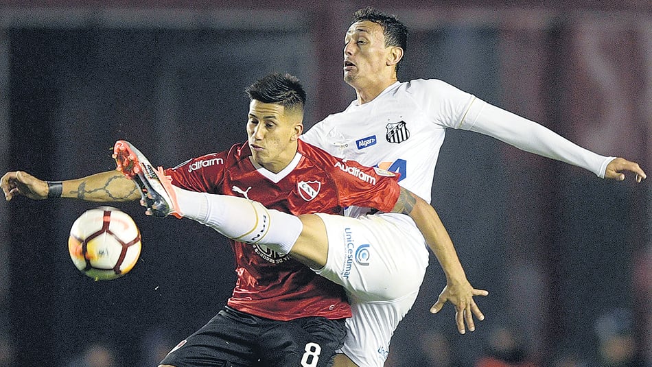 Meza disputa la pelota con el brasileño Pituca. El Rojo apenas empató 0-0 con Santos.