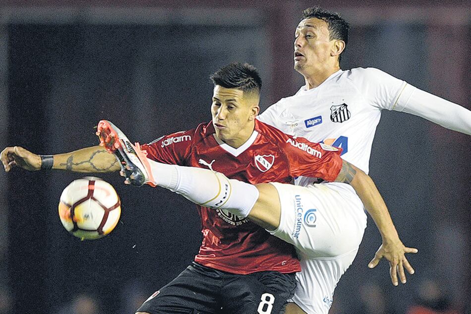 Meza disputa la pelota con el brasileño Pituca. El Rojo apenas empató 0-0 con Santos.