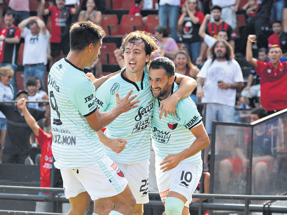 Tras convertir el único tanto con el que Colón madrugó a Lanús, Pereyra festeja junto a Bernardi y Leguizamón.