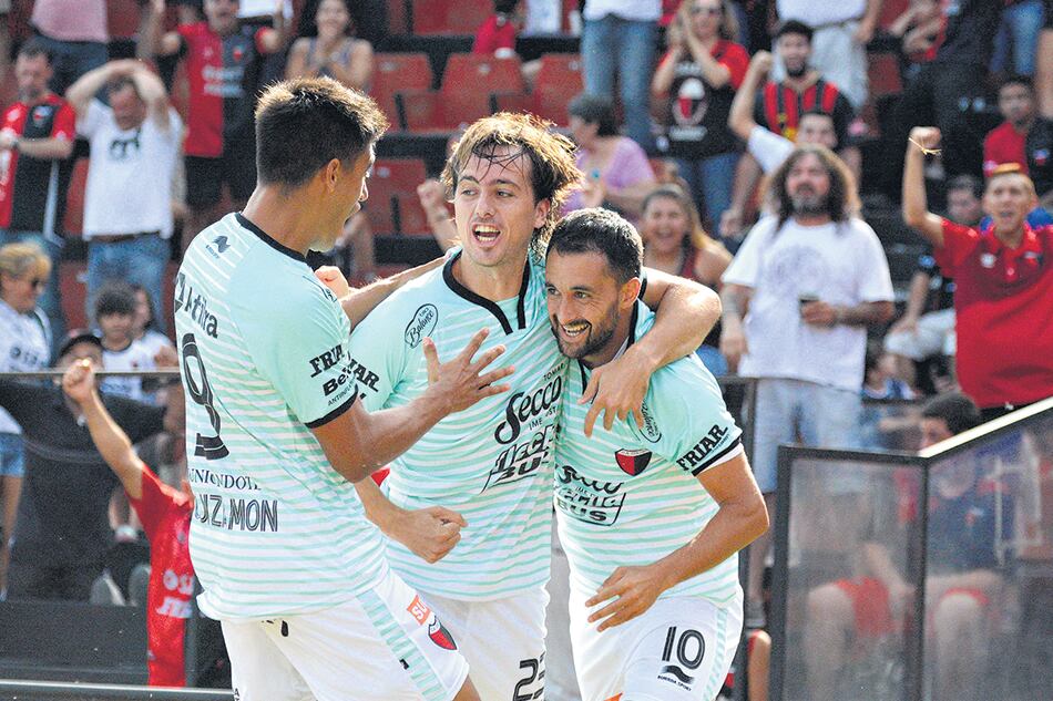 Tras convertir el único tanto con el que Colón madrugó a Lanús, Pereyra festeja junto a Bernardi y Leguizamón.