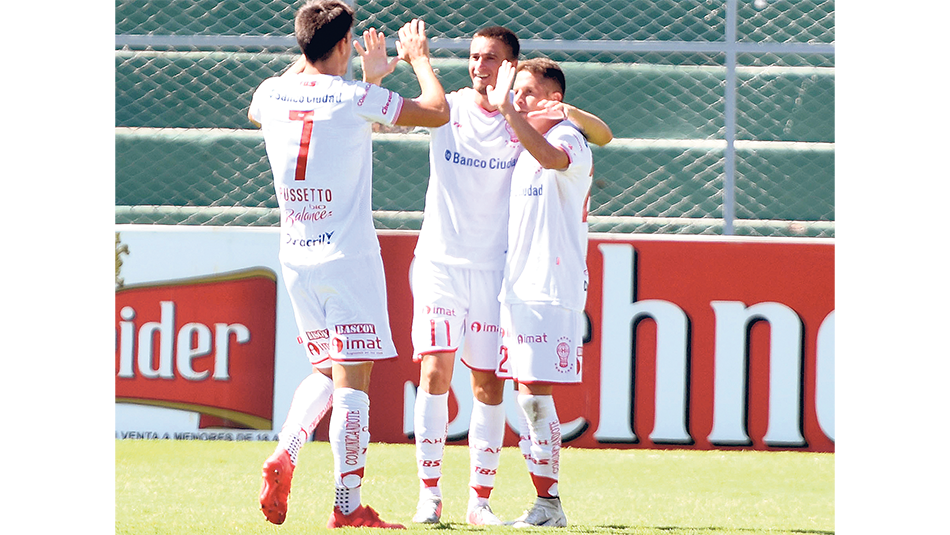 Pussetto (7) y Noir (11) felicitan al goleador Nicolás Silva.