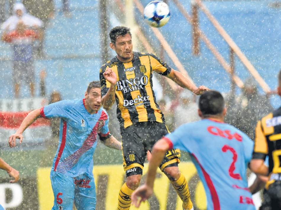 Cabezazo bajo la lluvia. El partido se paró porque la pelota no rodaba.