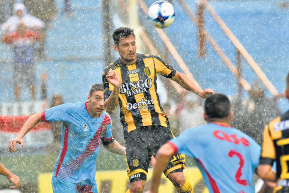 Cabezazo bajo la lluvia. El partido se paró porque la pelota no rodaba.