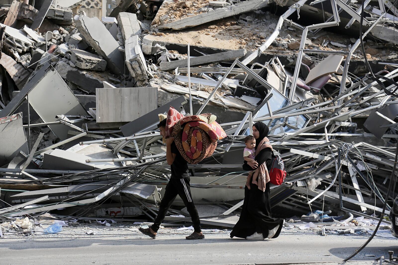 Una familia abandona una Cuidad de Gaza en ruinas con lo que puede cargar.