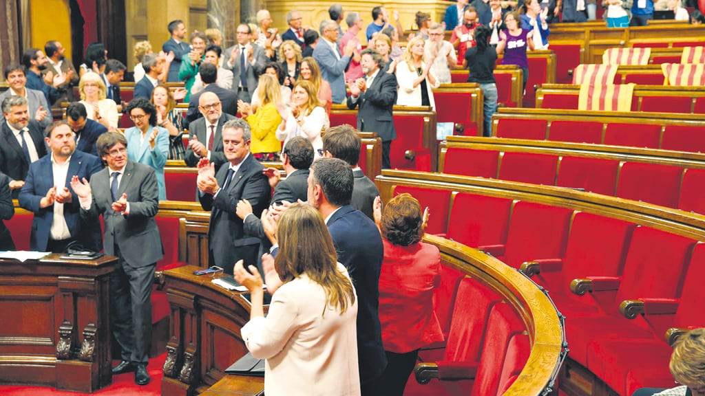 Puigdemont (segundo, abajo) y miembros de su gobierno festejan la votación en el Parlamento catalán.