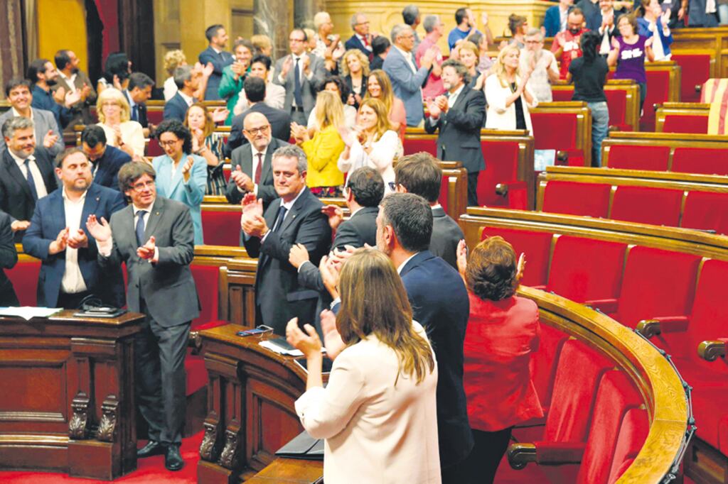 Puigdemont (segundo, abajo) y miembros de su gobierno festejan la votación en el Parlamento catalán.