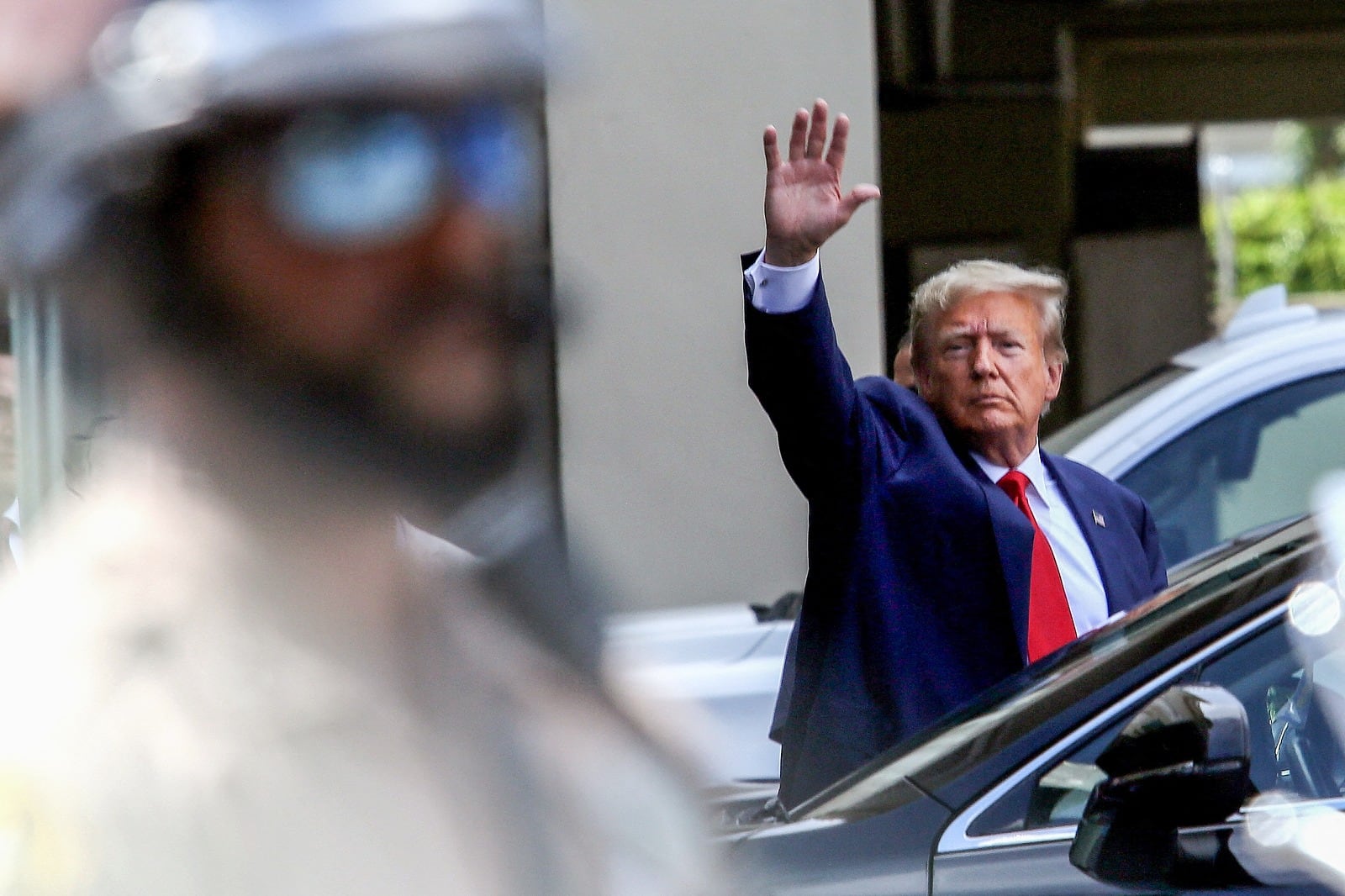 Trump saluda después de su cita judicial en Miami.