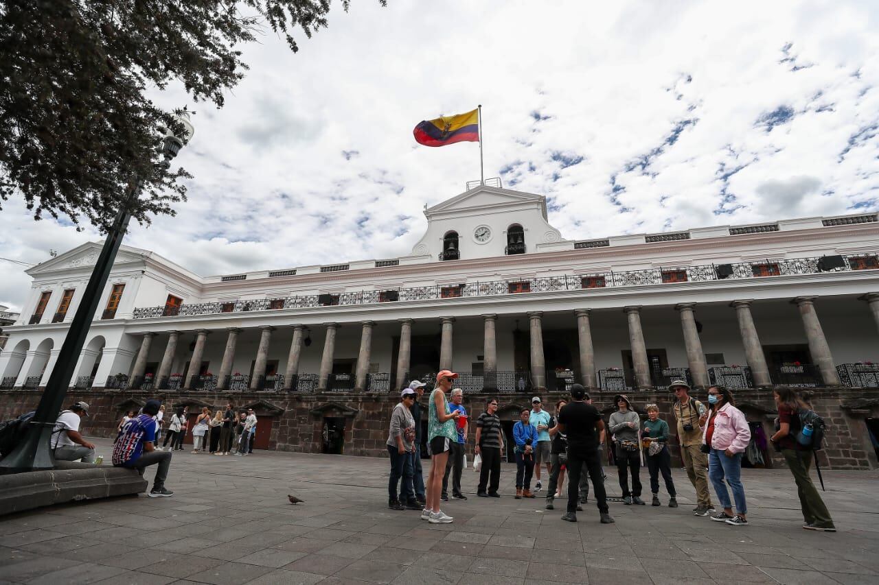 Ciudadanos ecuatorianos caminan a las afueras del Palacio de Gobierno este viernes en Quito