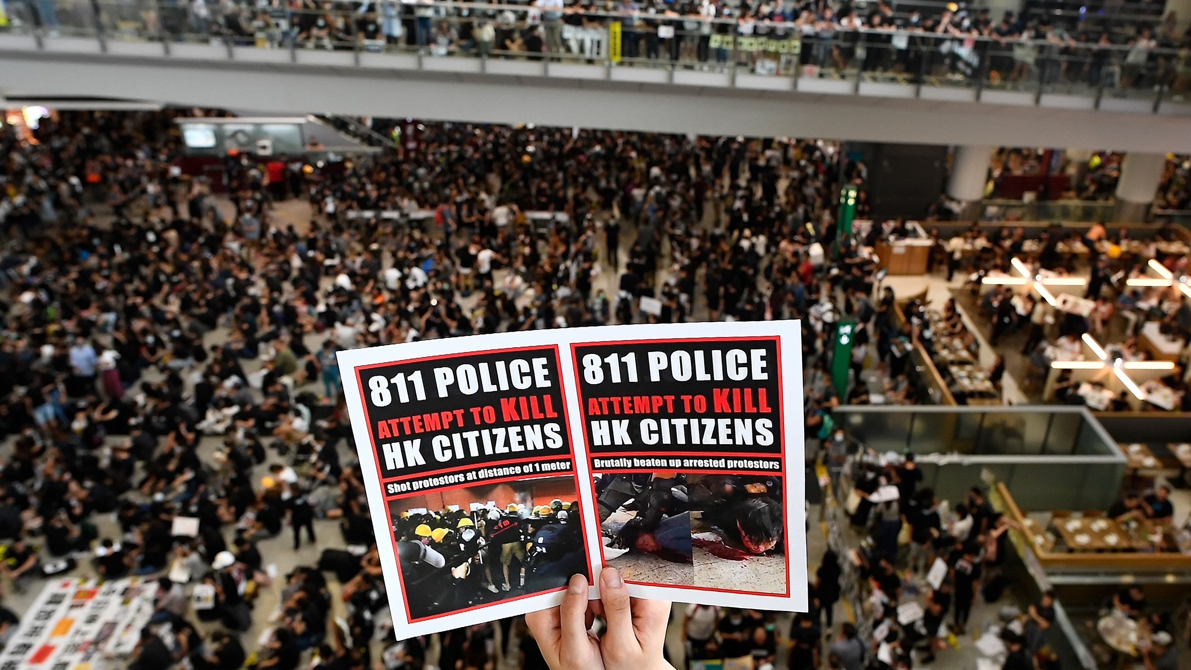 "La policía intenta matar a los ciudadanos de Hong Kong", dice el cartel.