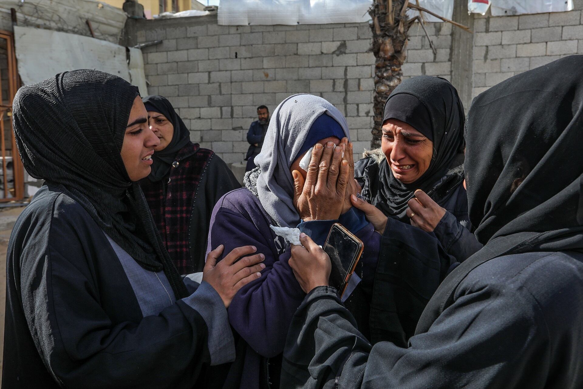 Mujeres lloran a sus seres queridos, asesinados por Israel durante su bombardeo nocturno sobre Gaza.
