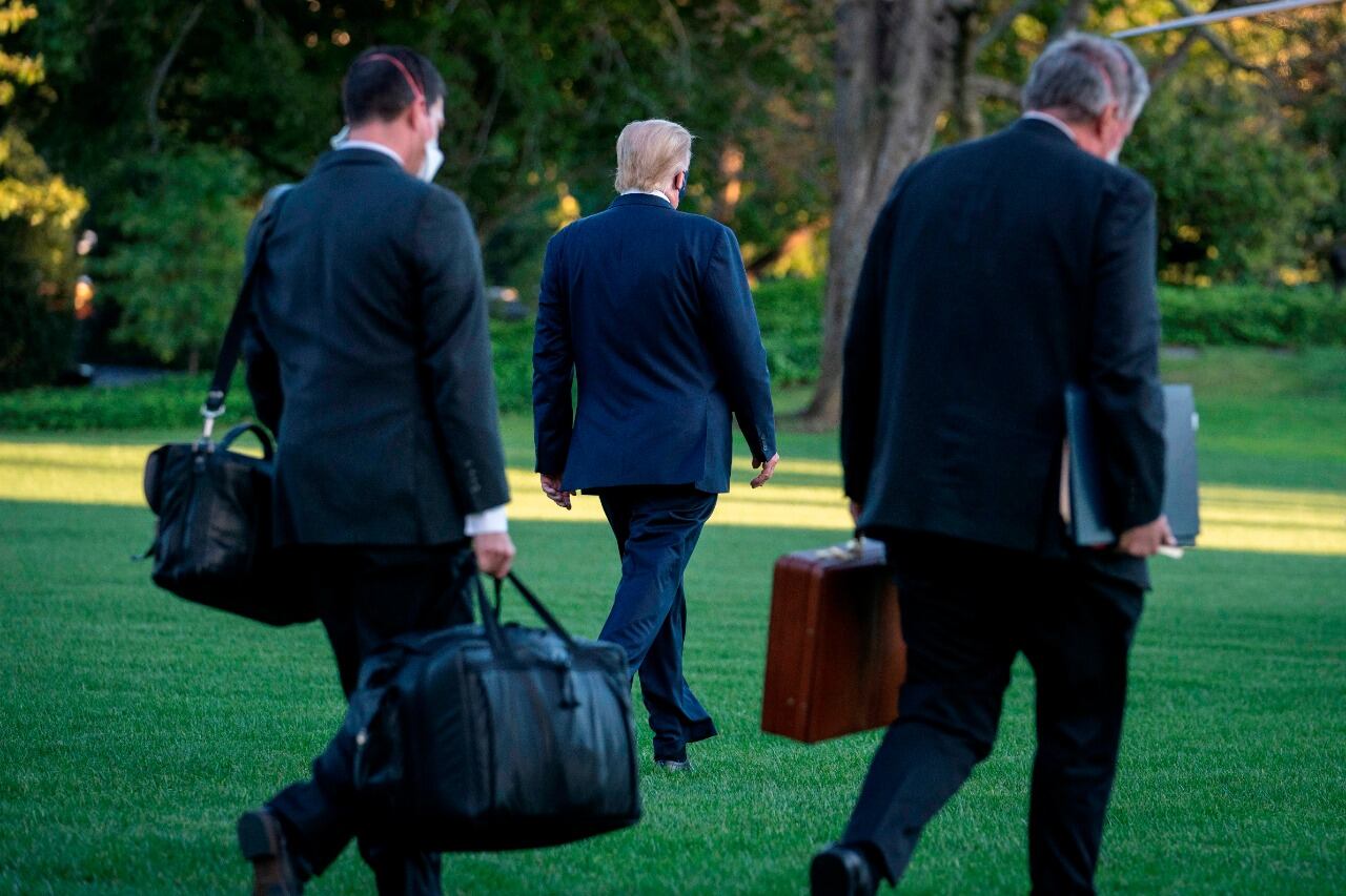 Trump camina rumbo al helicóptero que lo llevó a su internación en el centro médico Walter Reed este viernes.