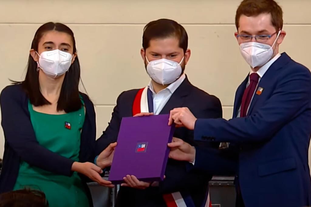 María Elisa Quinteros y Gaspar Domínguez entregan el texto de la nueva Constitución de Chile al presidente. Gabriel Boric. Foto: captura de video de la ceremonia.