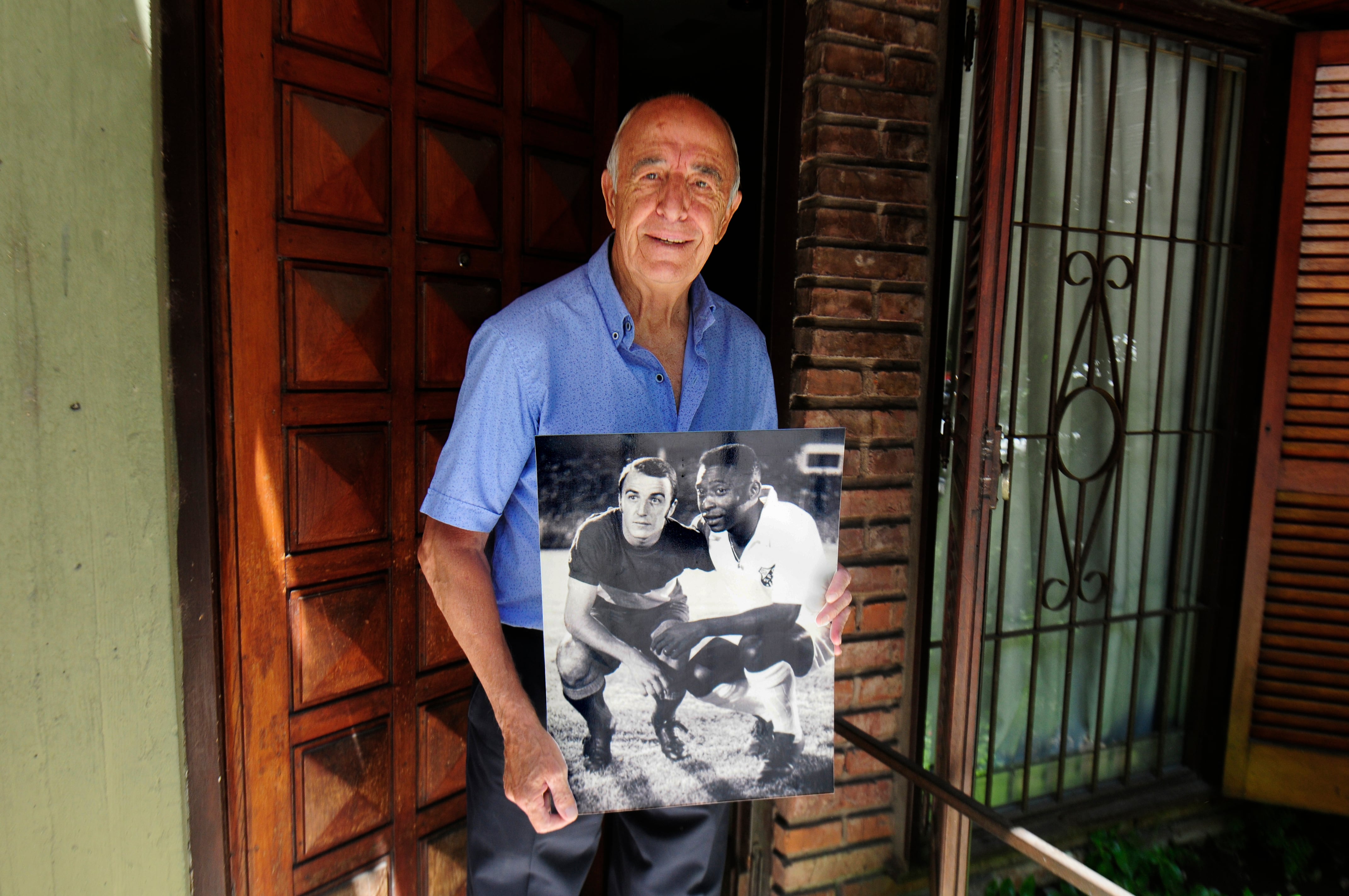 Madurga sostiene una foto junto a Pelé en la puerta de su casa.