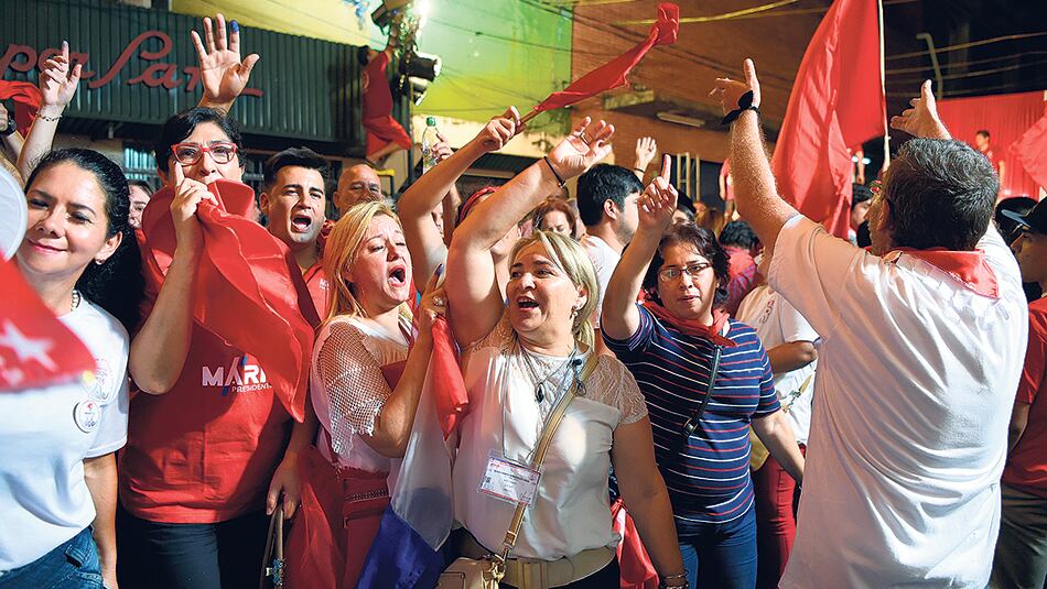 Simpatizantes del presidente electo Abdo Benítez festejan en el búnker de campaña del Partido Colorado en la capital paraguaya.