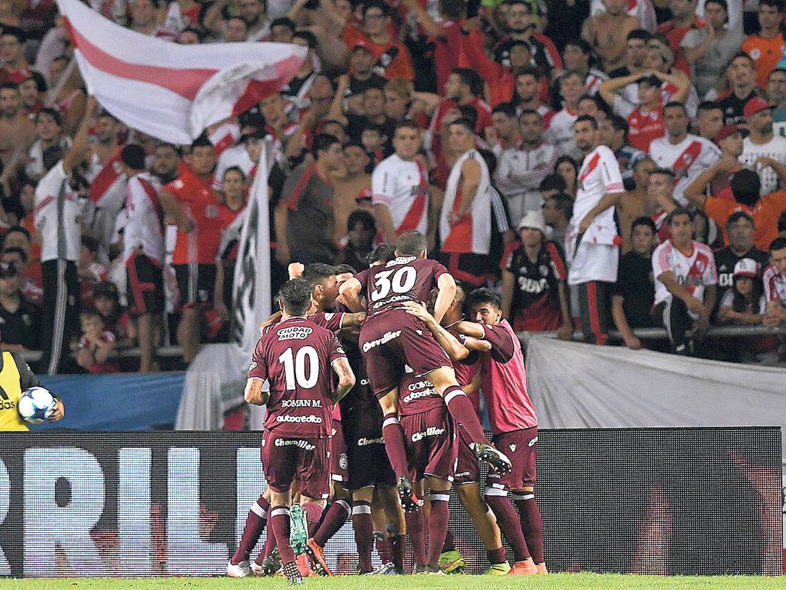 Todos abrazan al Pepe Sand, autor del penal que selló la victoria 3-0 para Lanús.
