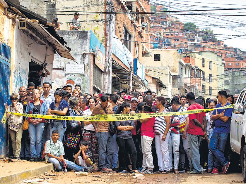 Un grupo de vecinos observa la panadería donde varias personas fueron electrocutadas.