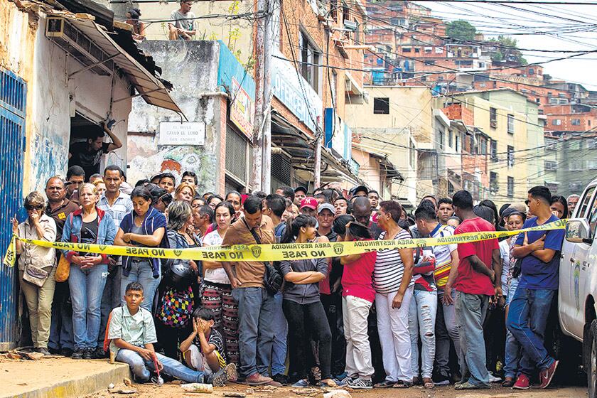 Un grupo de vecinos observa la panadería donde varias personas fueron electrocutadas.