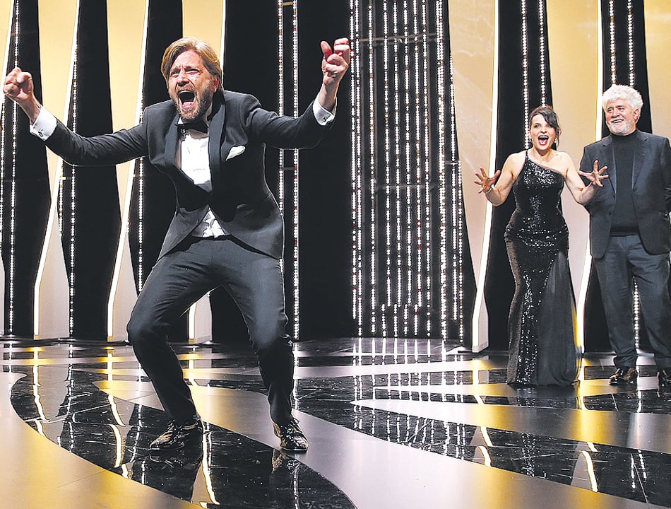 El sueco Ruben Östlund festeja su Palma de Oro ante la mirada cómplice de Juliette Binoche y Pedro Almodóvar.