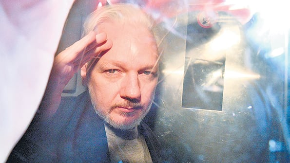 Después de la audiencia, Assange saluda desde el vehículo que lo lleva de vuelta a la cárcel.