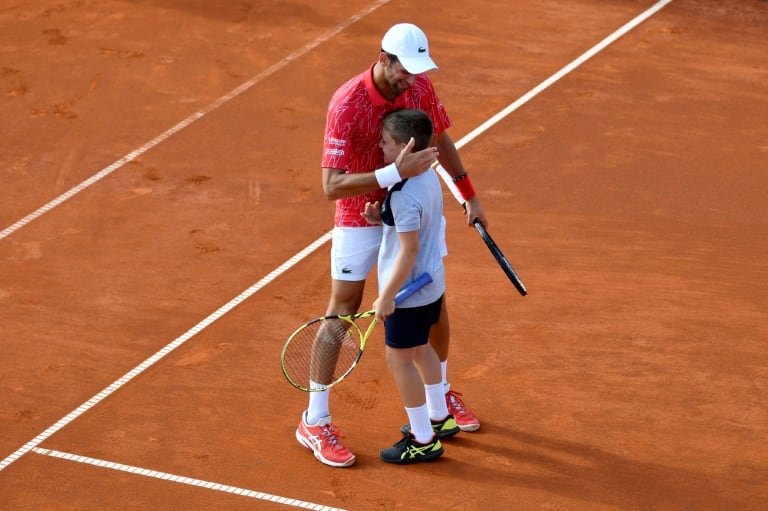Djokovic, con un alcanzapelotas, en el torneo exhibición en Belgrado.