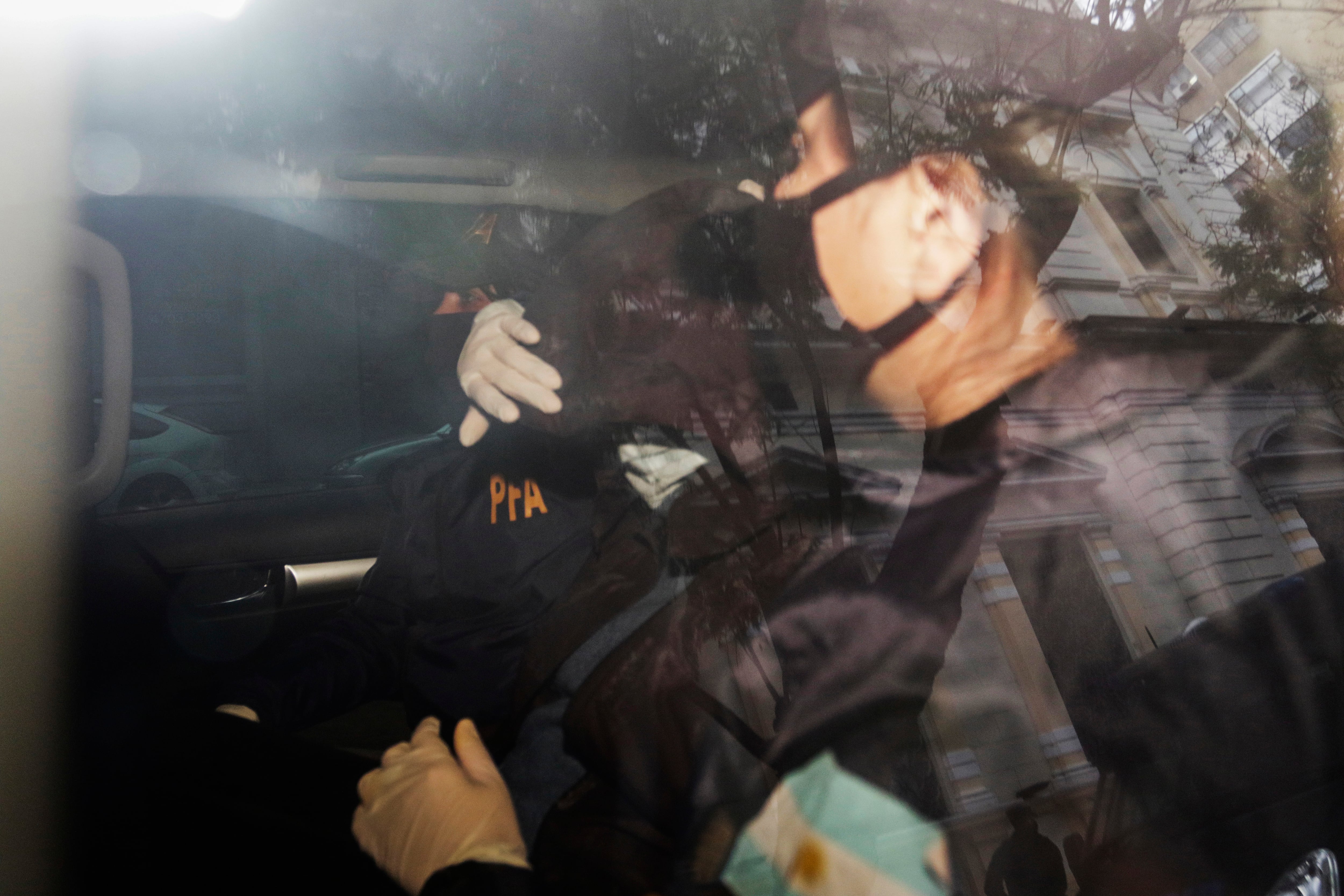 El momento en que la Policía Federal trasladaba a Susana Martinengo (con la cabeza tapada) al Juzgado de Lomas de Zamora.