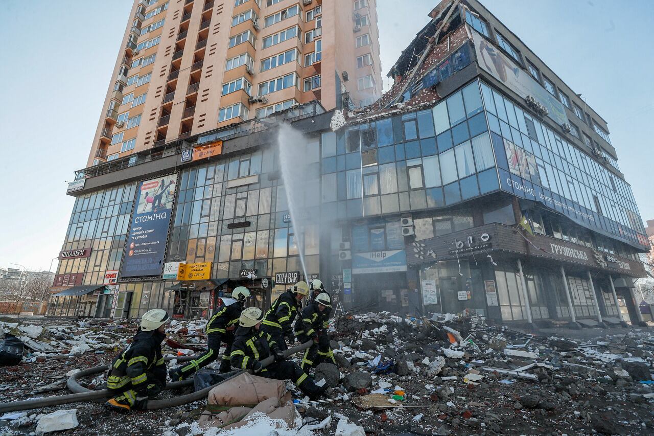 Bomberos ucranianos trabajan en un edificio bombardeado en Kiev.