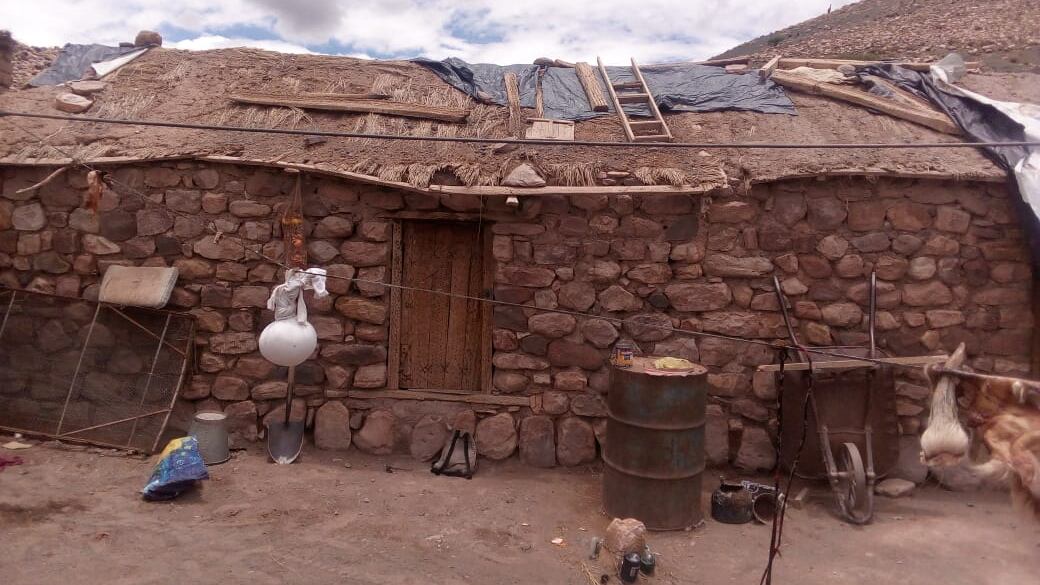 Casas con techos de adobe y plásticos en el techo para protegerlos 
