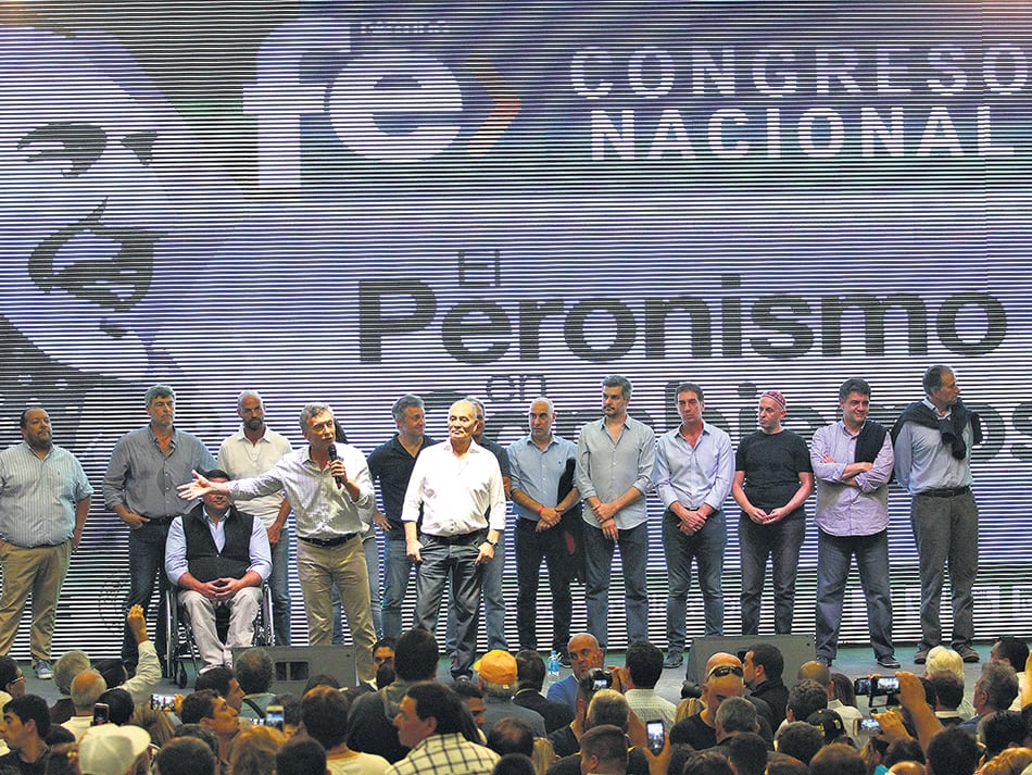 El Presidente y su gabinete detrás del cartel de “El Peronismo en Cambiemos” en el acto del club Ferro.
